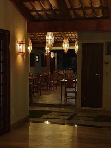 a dining room with tables and chairs and chandeliers at KUKA ZEN in Pirenópolis