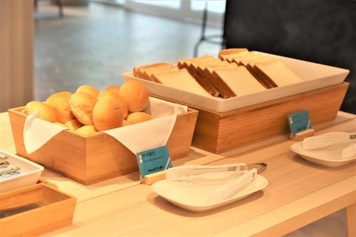 uma mesa com duas caixas de madeira de pão e queijo em Meant to Be em Chiayi