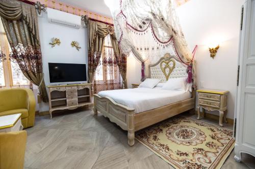 1 dormitorio con 1 cama, TV y cortinas en Studio Romantique Maison de L'église du Couvent, en Narbona