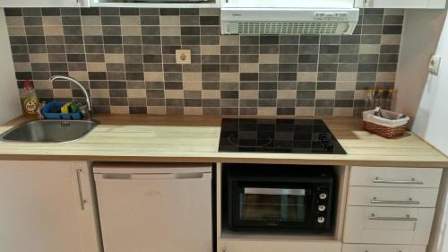 a kitchen with a sink and a stove top oven at Casa do Pelourinho - T1 in Loriga