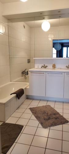 La salle de bains est pourvue d'une baignoire, d'un lavabo et d'un miroir. dans l'établissement Bruges Grande Place Guesthouse, à Bruges