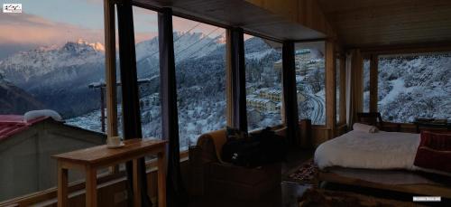 a bedroom with a view of a snow covered mountain at Mountain Rover Auli Resort in Joshīmath