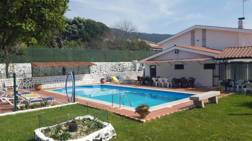 a swimming pool in a yard next to a house at VIVENDA TABORDA in Viana do Castelo