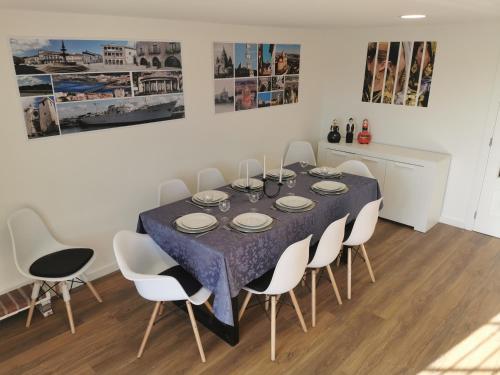 a dining room with a table and white chairs at VIVENDA TABORDA in Viana do Castelo