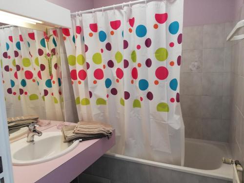 a bathroom with a shower curtain with a sink and a tub at Joli studio à DINARD /LA RICHARDAIS à 5 mn plage in La Richardais