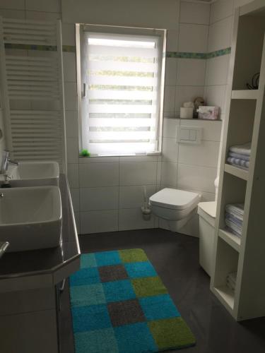 a bathroom with a sink and a toilet and a window at Tarrazza Ferienwohnungen Erpeldinger in Ellenz-Poltersdorf