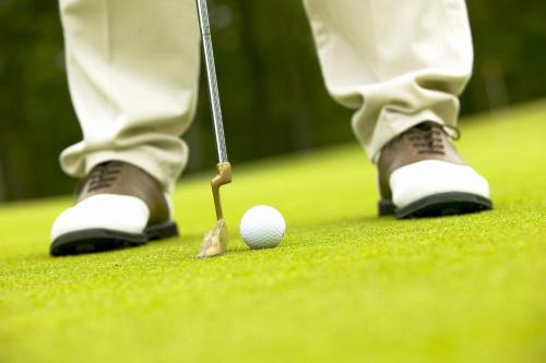 Ein Golfer wird gleich einen Golfball schlagen. in der Unterkunft Finca Prats Hotel Golf & Spa in Lleida