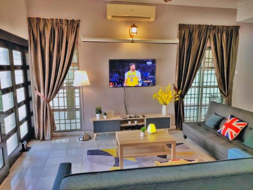 een woonkamer met een bank en een tv bij Semi-Detached, Up to 24 Pax, 3200sqft, 4 Bedrooms, 3 Bathrooms, 4 Car Parks in Bayan Lepas