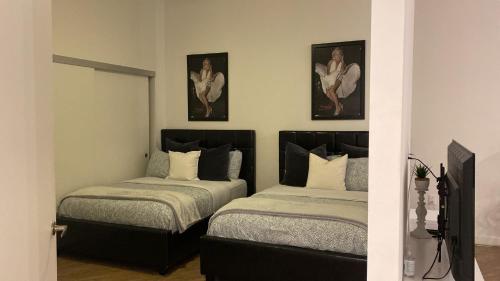 um quarto com duas camas e duas fotografias na parede em Exceptional Loft FREE Parking and WIFI em Los Angeles