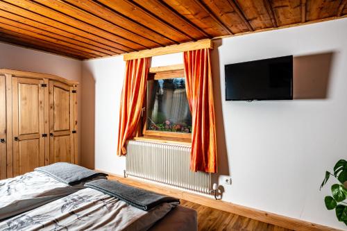 Schlafzimmer mit einem Bett und einem Flachbild-TV in der Unterkunft Rainerhof in Murau