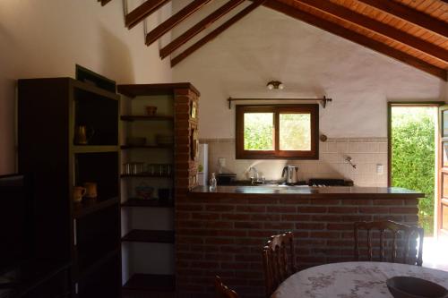 eine Küche mit Spüle und Tisch in einem Zimmer in der Unterkunft El jagüel in Villa General Belgrano
