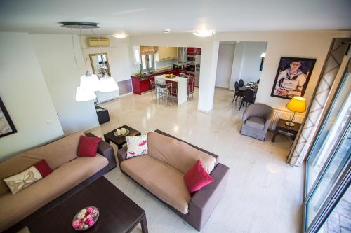 a living room with two couches and a kitchen at Thealos Village aparthotel Lefkada in Lygia