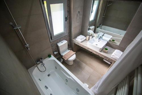 a bathroom with a tub and a toilet and a sink at Thealos Village aparthotel Lefkada in Lygia