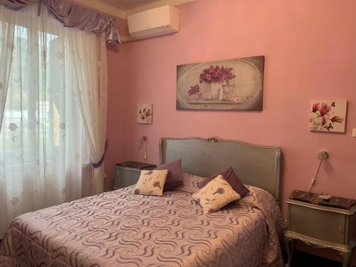 Un dormitorio con una cama con paredes rosas y una ventana en La Maison Di Caterina, en Génova