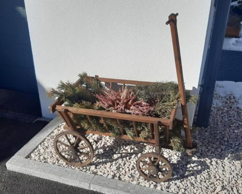 a wooden cart filled with plants on a sidewalk at Ferienwohnung Widmann in Jochberg