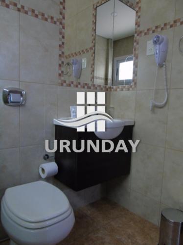a bathroom with a toilet and a sink and a mirror at Urunday Apart Hotel in Posadas