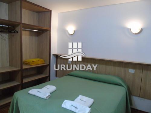 a bedroom with a green bed with towels on it at Urunday Apart Hotel in Posadas
