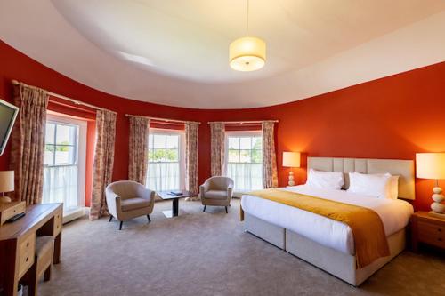 a bedroom with a large bed and red walls at Butler House in Kilkenny