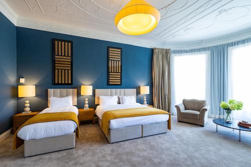 a bedroom with two beds and a blue wall at Butler House in Kilkenny