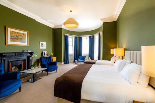 a bedroom with a large bed and a fireplace at Butler House in Kilkenny