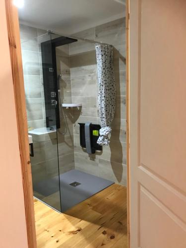 a glass door with a dispenser in a bathroom at Chambre d'hôte aux Pivoines in Nistos