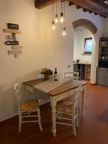 tavolo da pranzo con sedie e bottiglia di vino di Home sweet home a San Gimignano