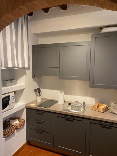 a kitchen with gray cabinets and a sink at Home sweet home in San Gimignano