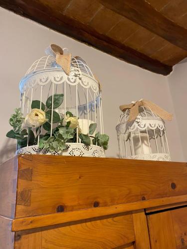 a bird cage with flowers in it on a wooden table at Home sweet home in San Gimignano