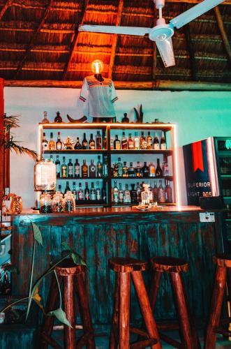 a bar with wooden stools in a room at Aldea Che-Eek , con acceso a un club de playa privado in Bacalar