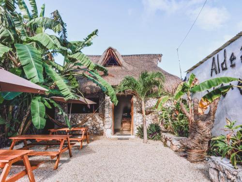 a building with tables and benches in front of it at Aldea Che-Eek , con acceso a un club de playa privado in Bacalar