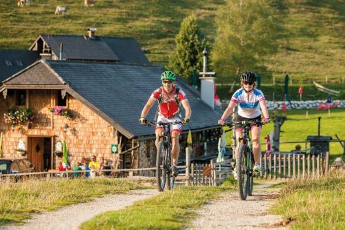 two people riding bikes down a dirt road at Hoferbauergut in Strobl