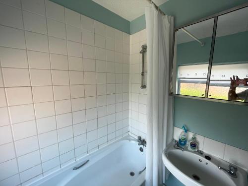 a bathroom with a tub and a sink and a mirror at Flat 4 Cleethorpes apts in Cleethorpes