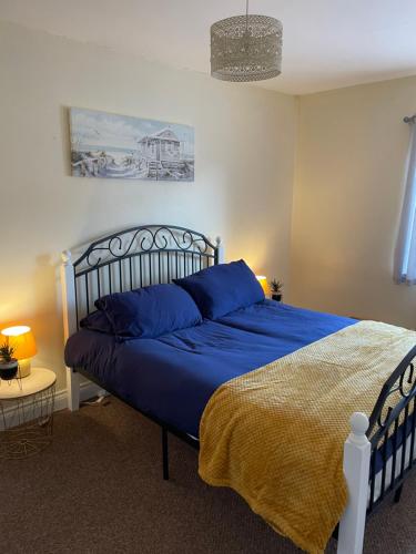 a bedroom with a blue bed with a blue blanket at Flat 4 Cleethorpes apts in Cleethorpes