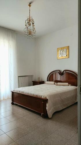 a large bed in a bedroom with a chandelier at Masseria Parco delle Casette in Alberobello