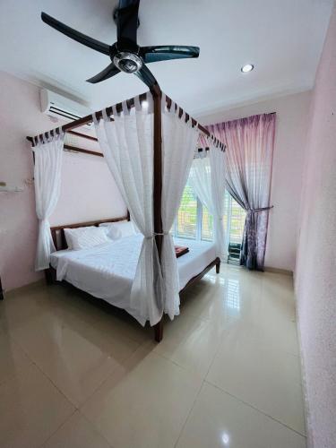 a bedroom with a bed with a ceiling fan at Homestay Seri Pangkor in Pangkor