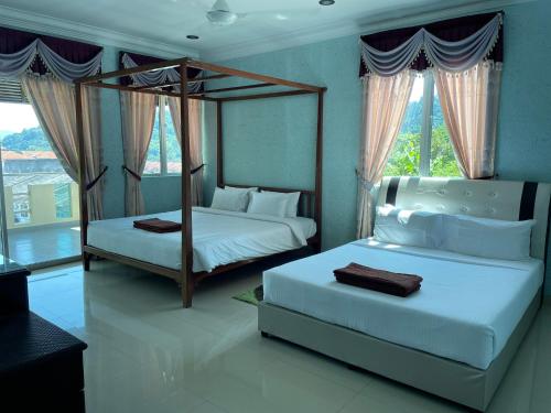 a bedroom with two beds and a window at Homestay Seri Pangkor in Pangkor