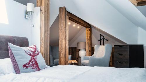 a bedroom with a bed and two chairs in a attic at Villa Ambach in Oetz