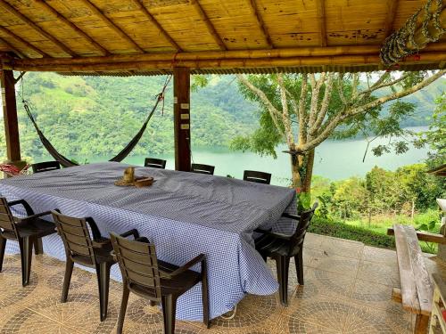 a table with chairs and a view of a lake at Ecohotel Los Mikos in Norcasia