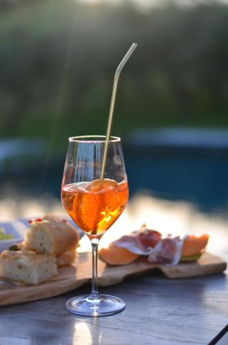 a glass of wine sitting on a table with food at La Cipressina B&B in Cavaion Veronese