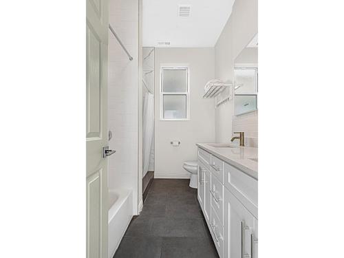 Baño blanco con lavabo y aseo en Spacious 5-BR Apt next to transit Free Parking, en Chicago