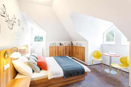 a bedroom with a bed and a table and chairs at Wellness Hotel Grand in Špindlerův Mlýn