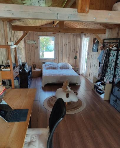 - une chambre avec un lit et un ordinateur portable sur une table dans l'établissement Maison familiale en bois avec piscine, proche du bassin, à Gujan-Mestras