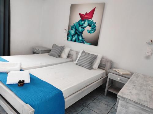 ナウサにあるIsalos Parosのベッド2台が備わる客室で、壁には絵画が飾られています。