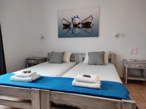 a bedroom with two beds with towels on them at Isalos Paros in Naousa