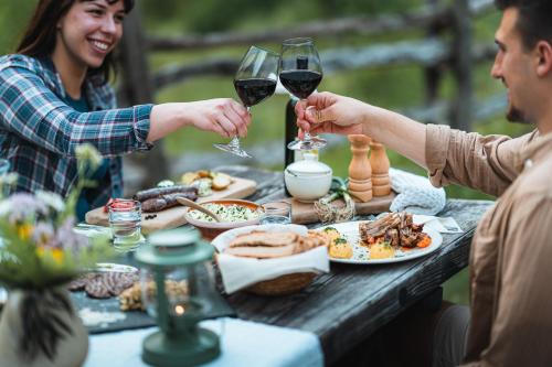 dos personas bebiendo vino en una mesa con comida en Organic Tourist Farm Pri Plajerju, en Trenta