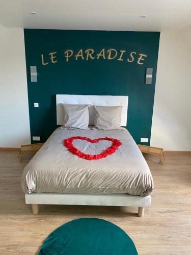- un lit avec un cœur rouge au-dessus dans l'établissement Le Paradise, à Ville-le-Marclet