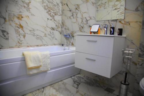 a bathroom with a white tub and a sink at Romantic luxury in city center in Cluj-Napoca