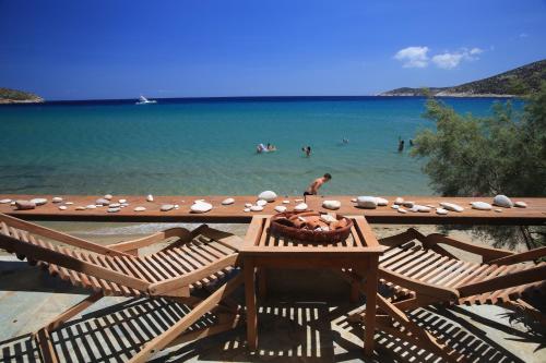 a beach with a table and chairs and the ocean at Kyprianos house in Platis Yialos Sifnos