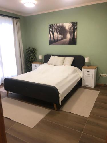 sypialnia z dużym łóżkiem i obrazem na ścianie w obiekcie Galéria Apartmanház w mieście Keszthely
