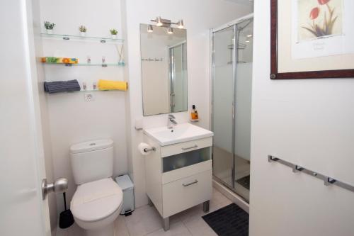 a bathroom with a toilet and a sink and a shower at Apartamento con Vistas al mar in Conil de la Frontera